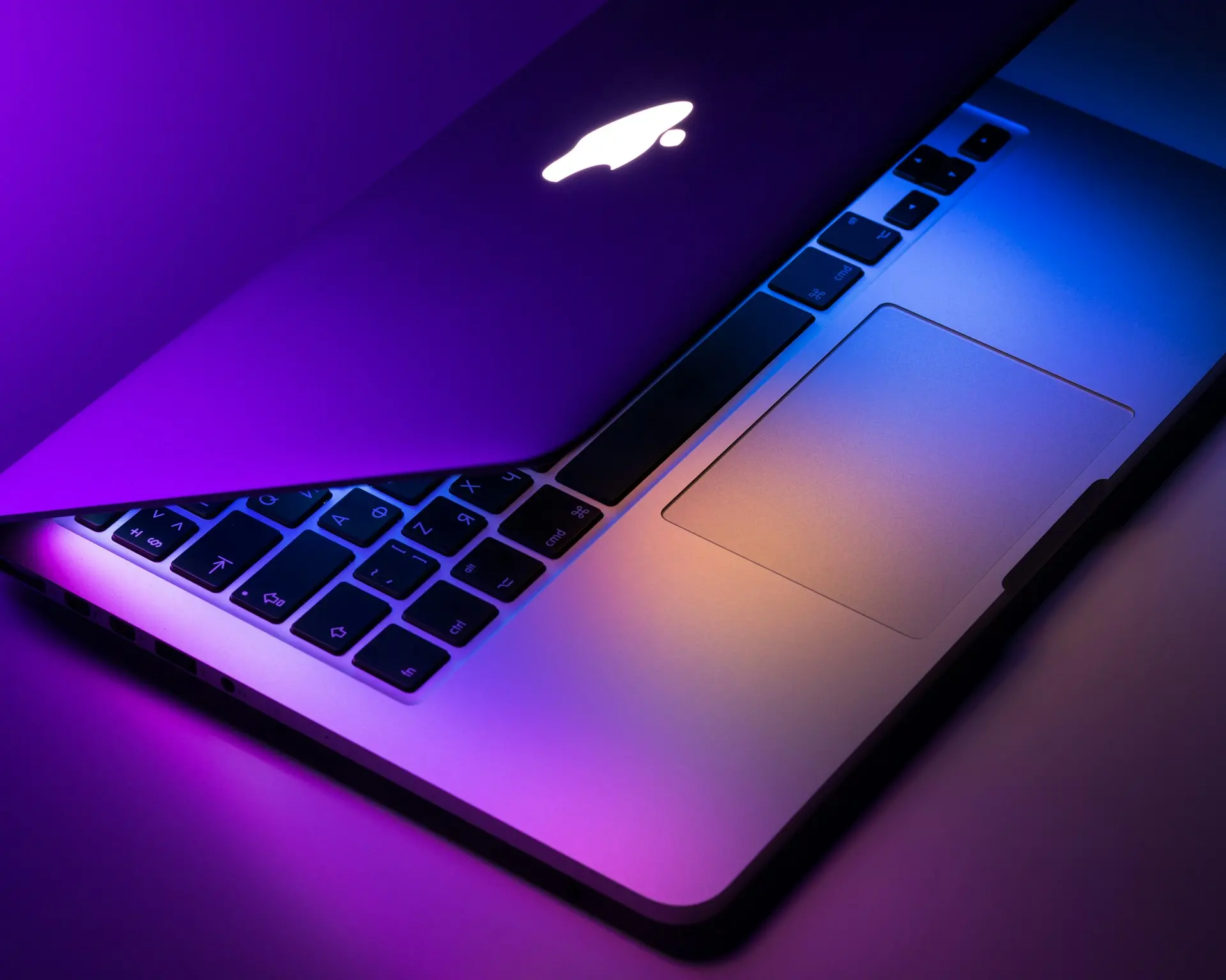 MacBook în lumini albastre și mov